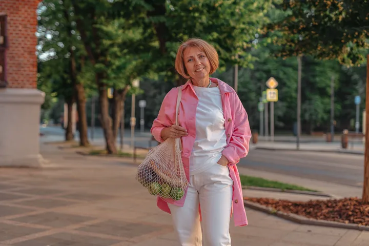 Mujer adulta caminando con una bolsa de mercado